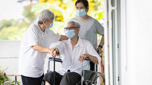 an Asian guy in a wheelchair talking to his wife and son