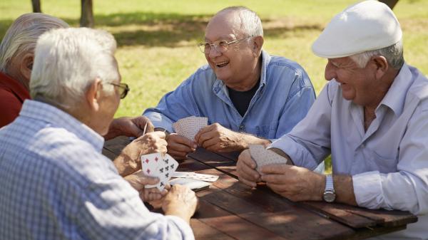 Image group of four elderly men at park bench