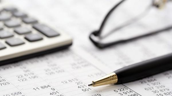 Image of a calculator, glasses, pen and spreadsheet showing schedules of Indexation rates for Residential Aged Care and Home Care Packages.