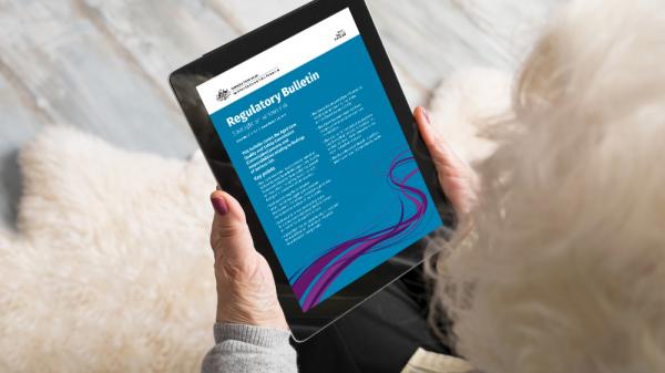 Image of older lady reading regulatory bulletin on an ipad